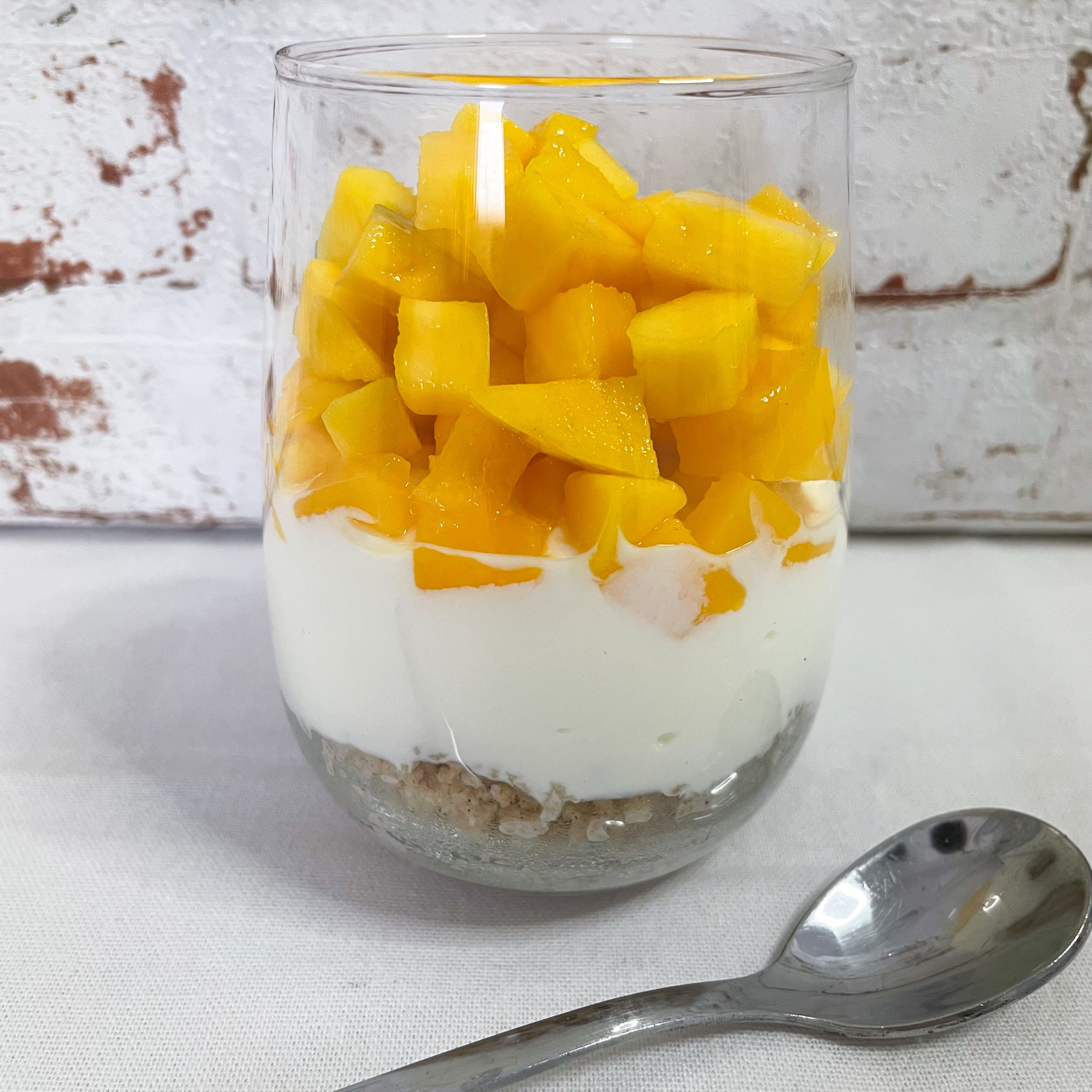 Schichtfrühstück im Glas mit Mango Couscous und Joghurt