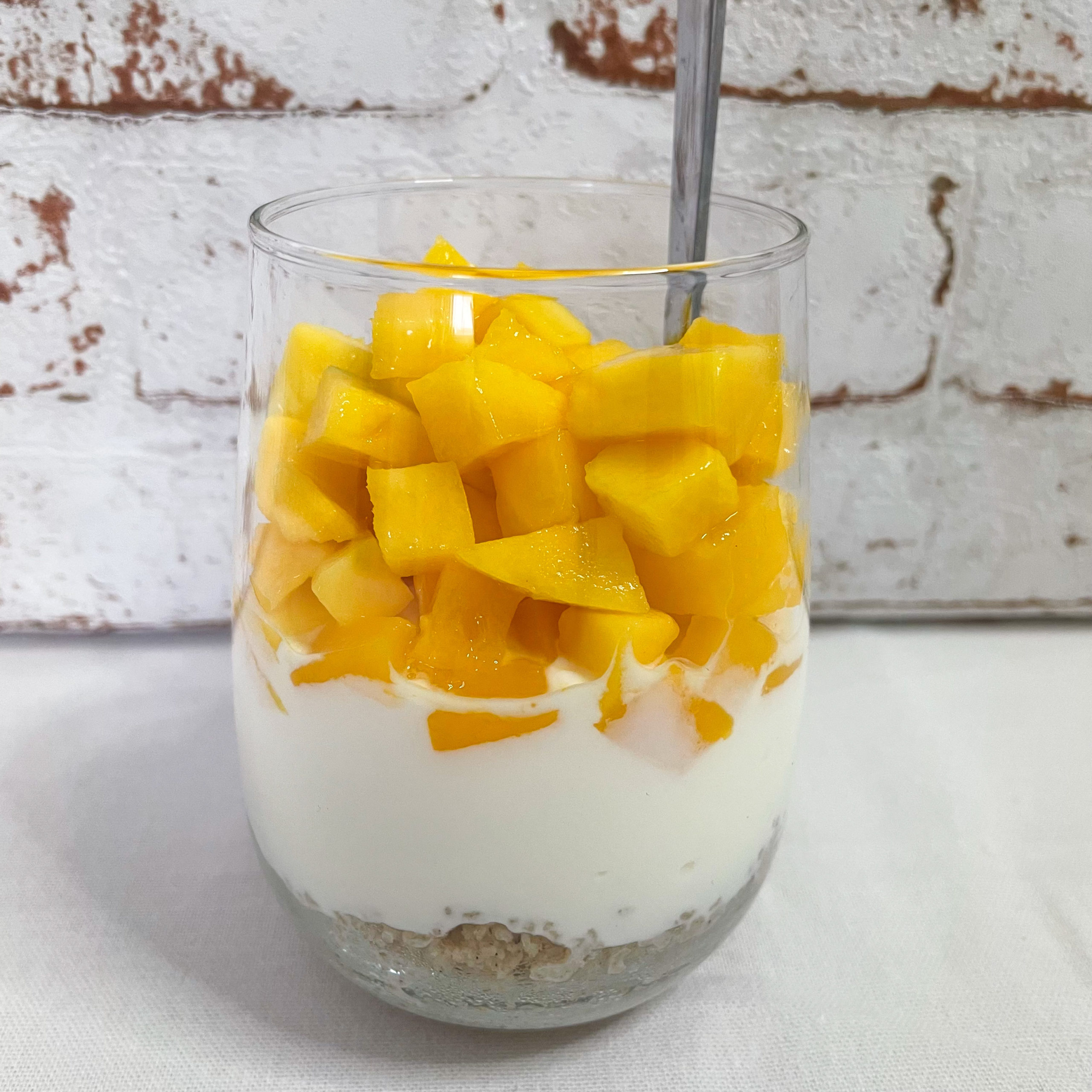 Schichtfrühstück im Glas mit Mango Couscous und Joghurt