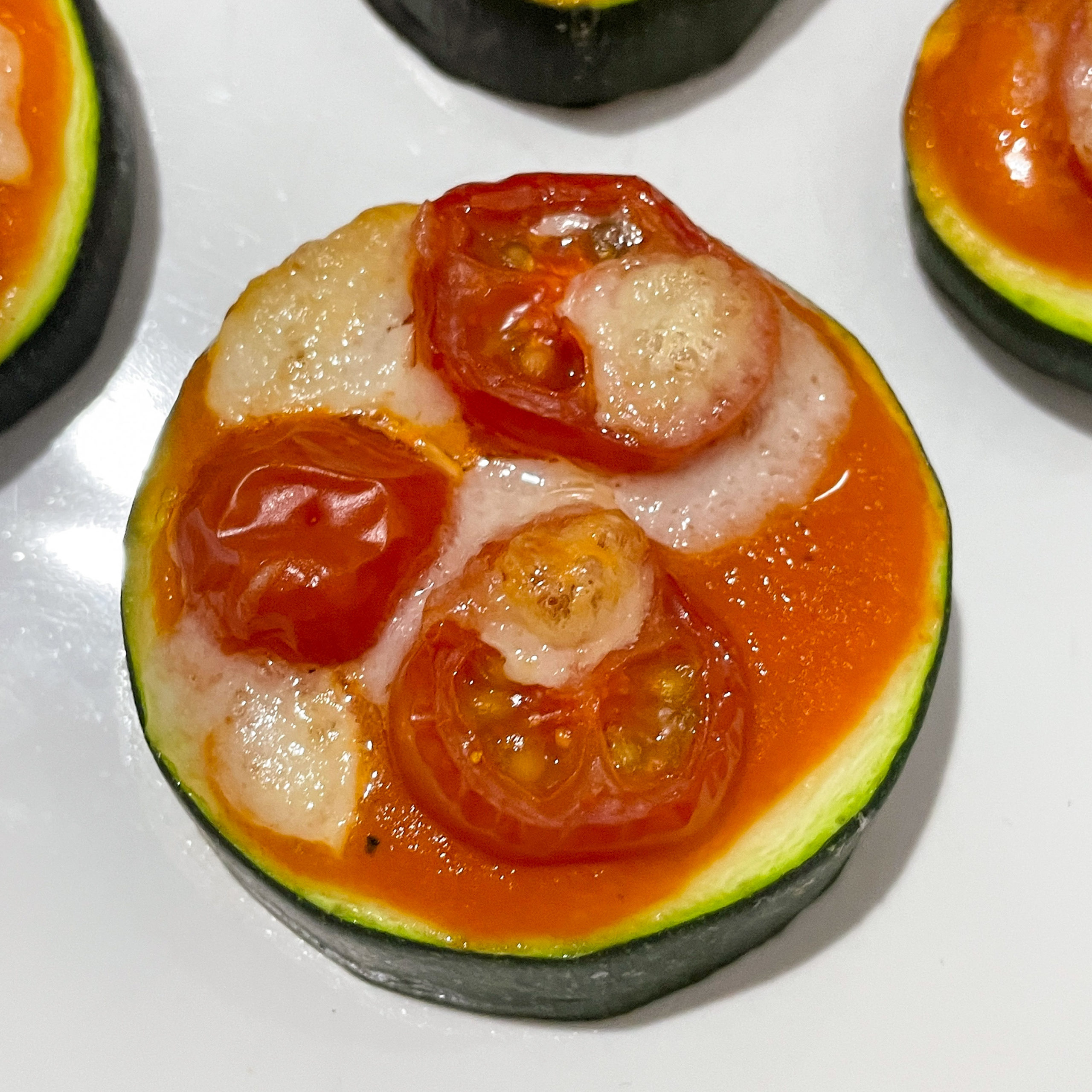 Low Carb Zucchini Pizza belegt mit Tomaten und Büffel Mozzarella